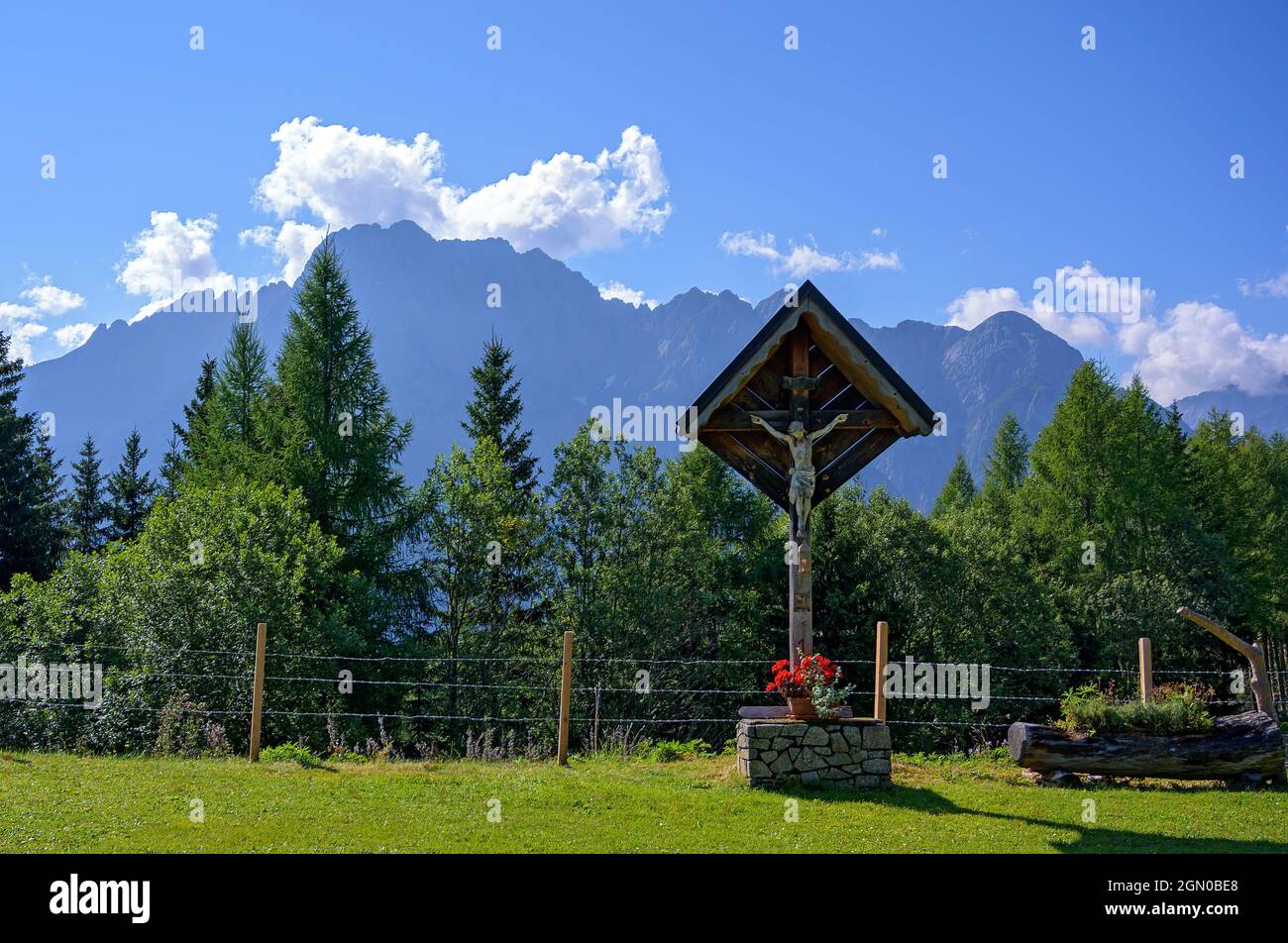 wayside cross on the Star alp above the town of Lienz with the Dolomites in the background, Austria Stock Photo