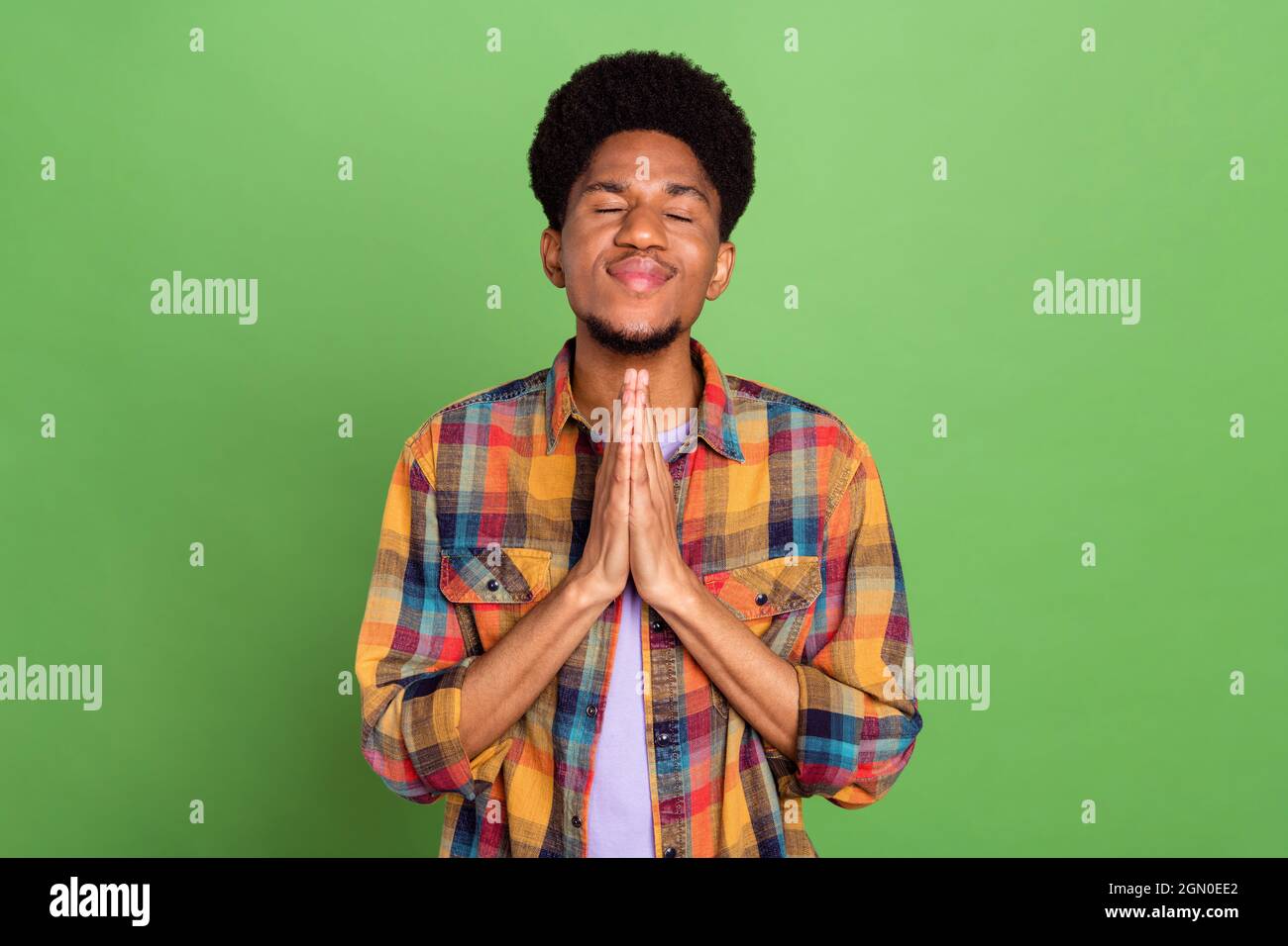 Photo of dreamy cute dark skin man wear plaid shirt arms together closed  eyes isolated green color background Stock Photo - Alamy