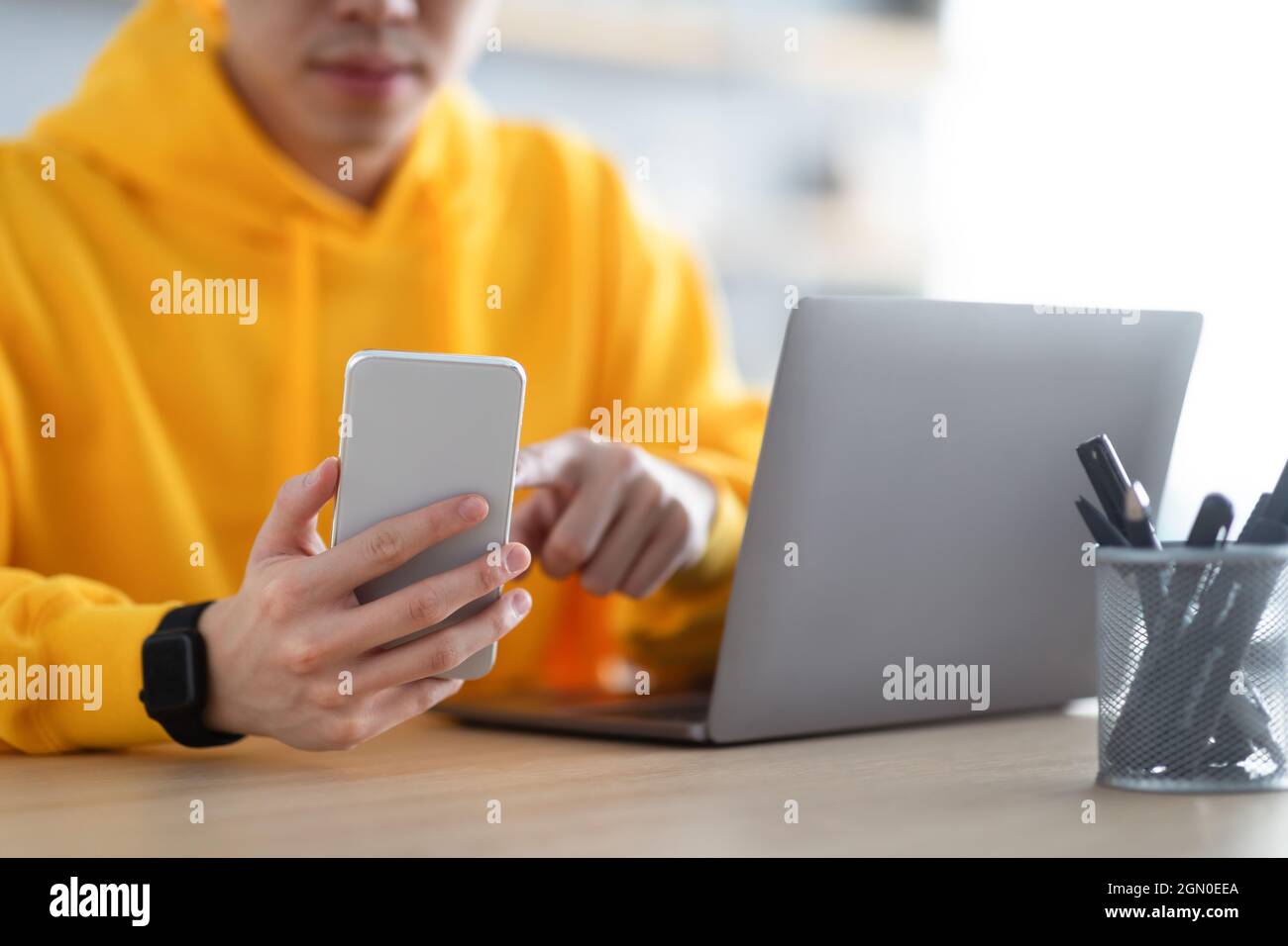 Closeup of man sitting at desk reading text message Stock Photo
