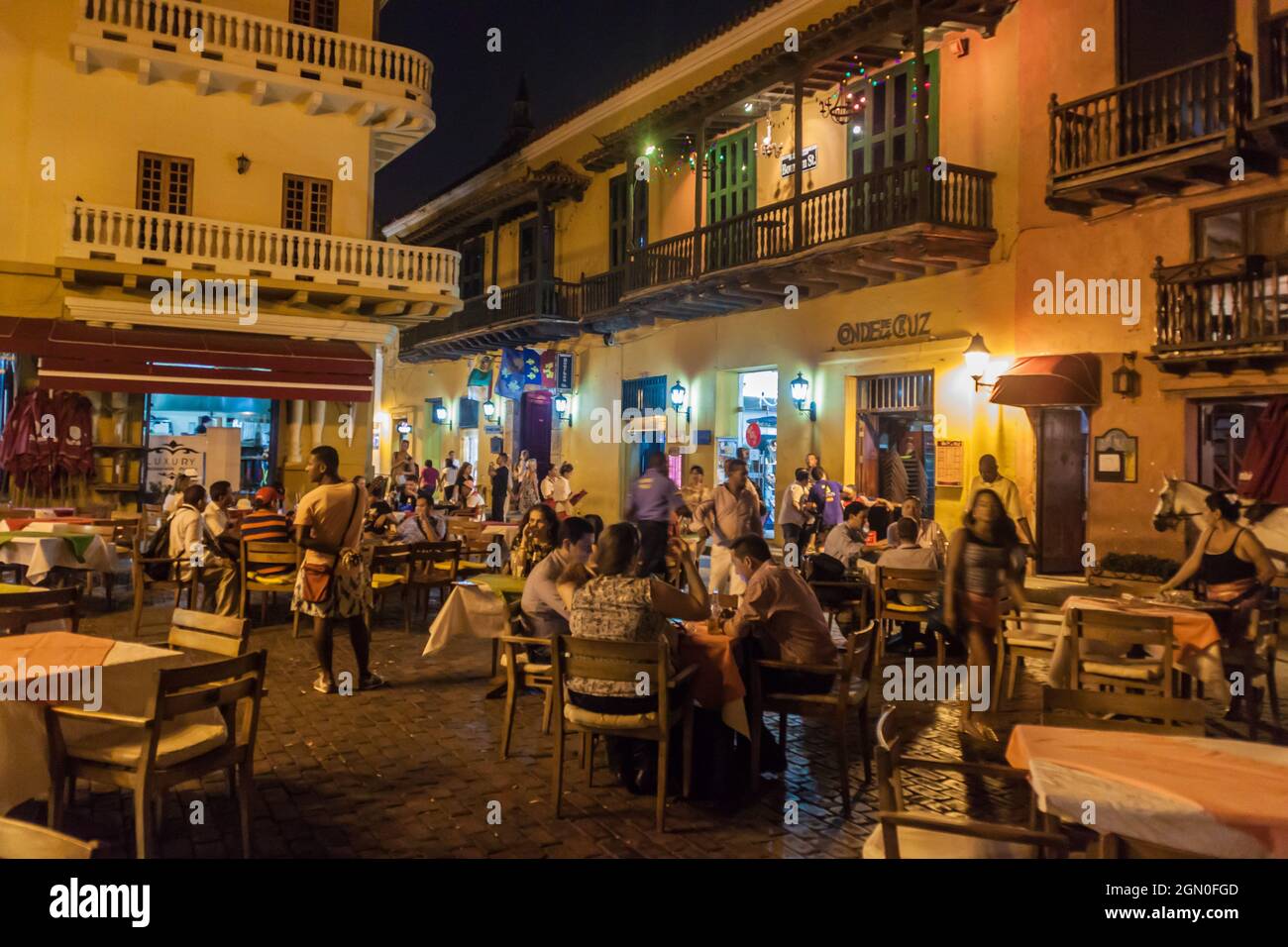 CARTAGENA DE INDIAS, COLOMBIA - AUG 27, 2015: People sit in cafes at Plaza Fernandez de Madrid square in Cartagena during the evening. Stock Photo