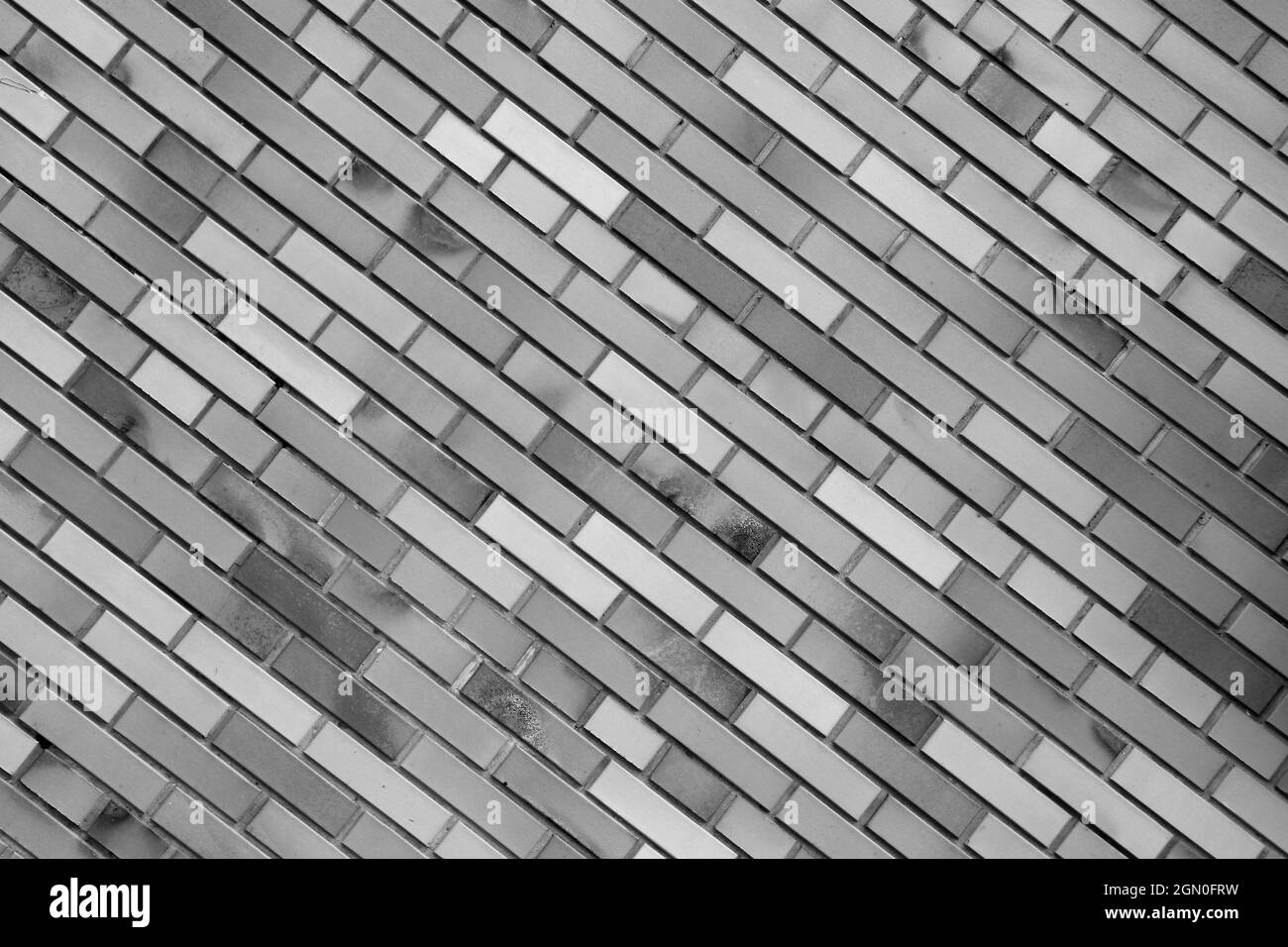 Vintage black white brick wall background, diagonal position, stone