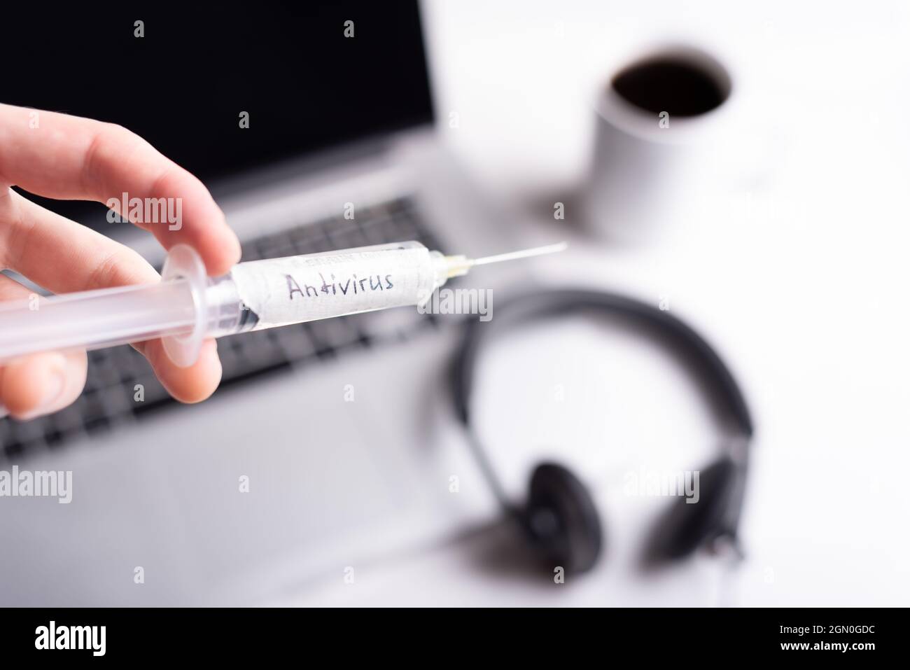 syringe with antivirus and cup of coffee on the background  Stock Photo
