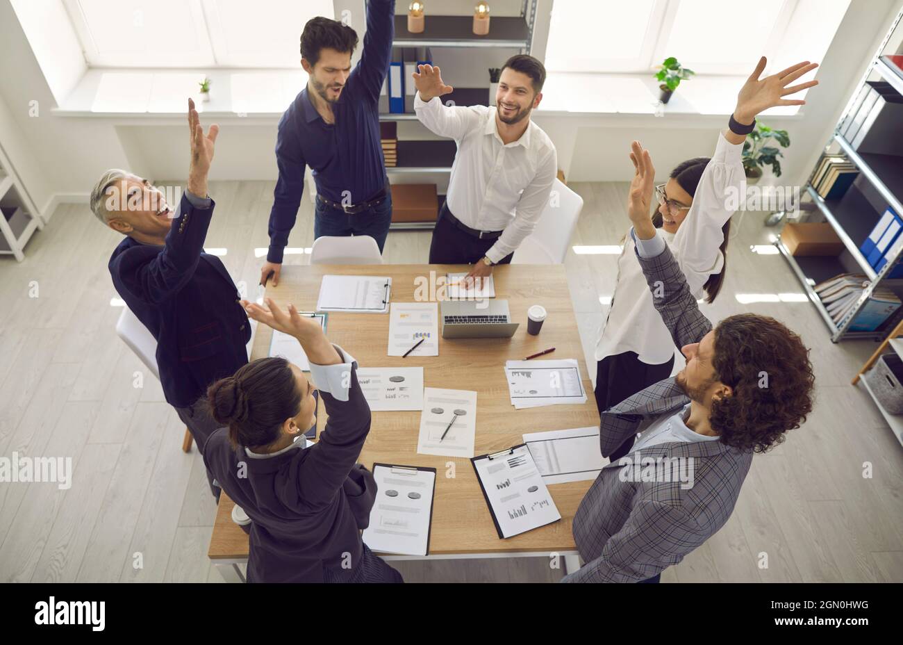 Excited Diverse Team Celebrating Corporate Business Success With Raised