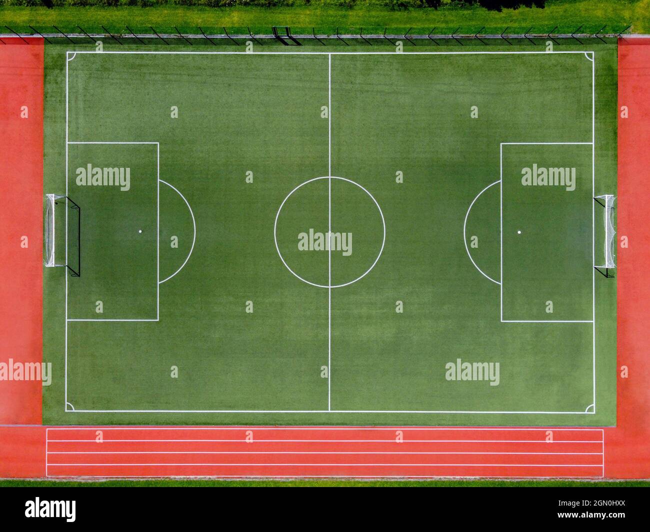 From above aerial view of empty green soccer field with white lines and goals on sports stadium in summer day Stock Photo