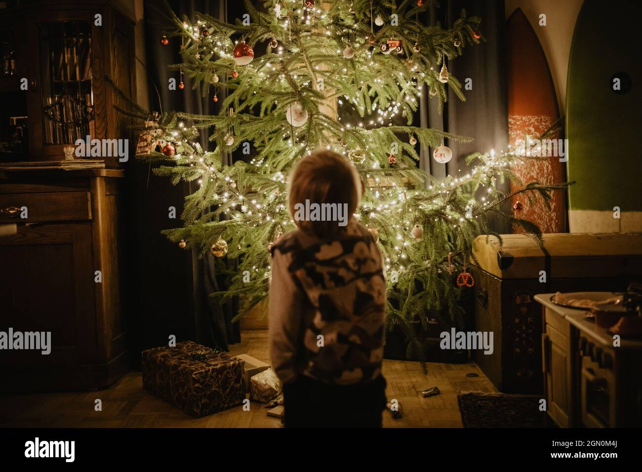 little boy stands in front of the Christmas tree, Christmas, family Stock Photo