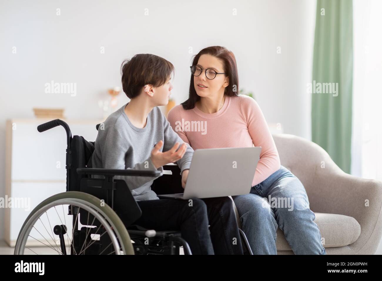 based education concept. Cheerful disabled teen boy in wheelchair