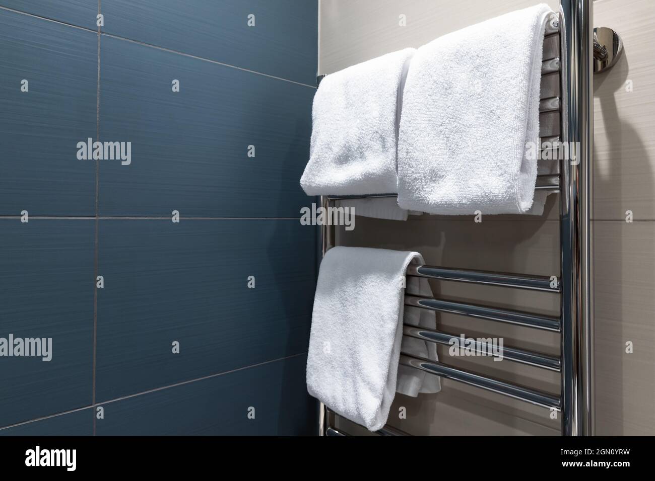 White towels are dried on a heated towel rail in the bathroom Stock