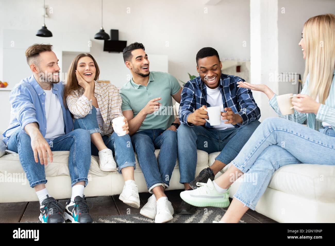Happy milturacial friends socializing, drinking tea, laughing, sitting ...