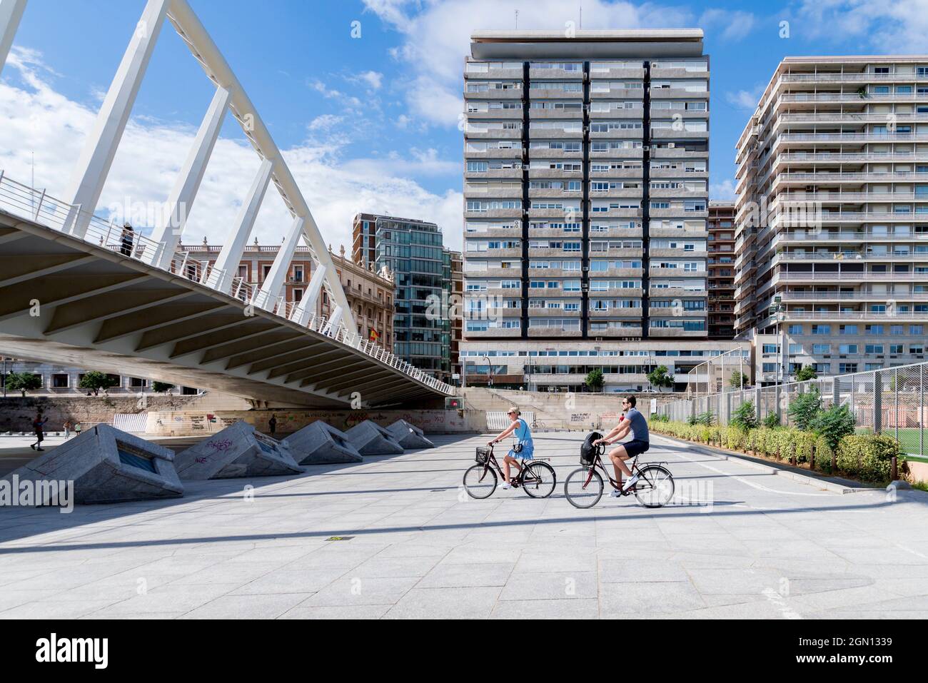 A Couple Seen Riding A Bicycle Near The Puente De La Exposicion Pont