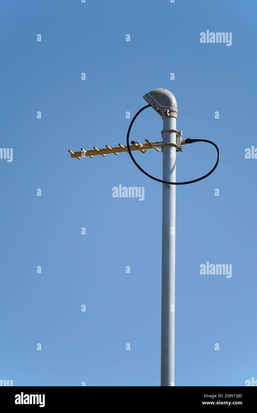 UHF radio antenna on a pole against blue sky portrait format Stock