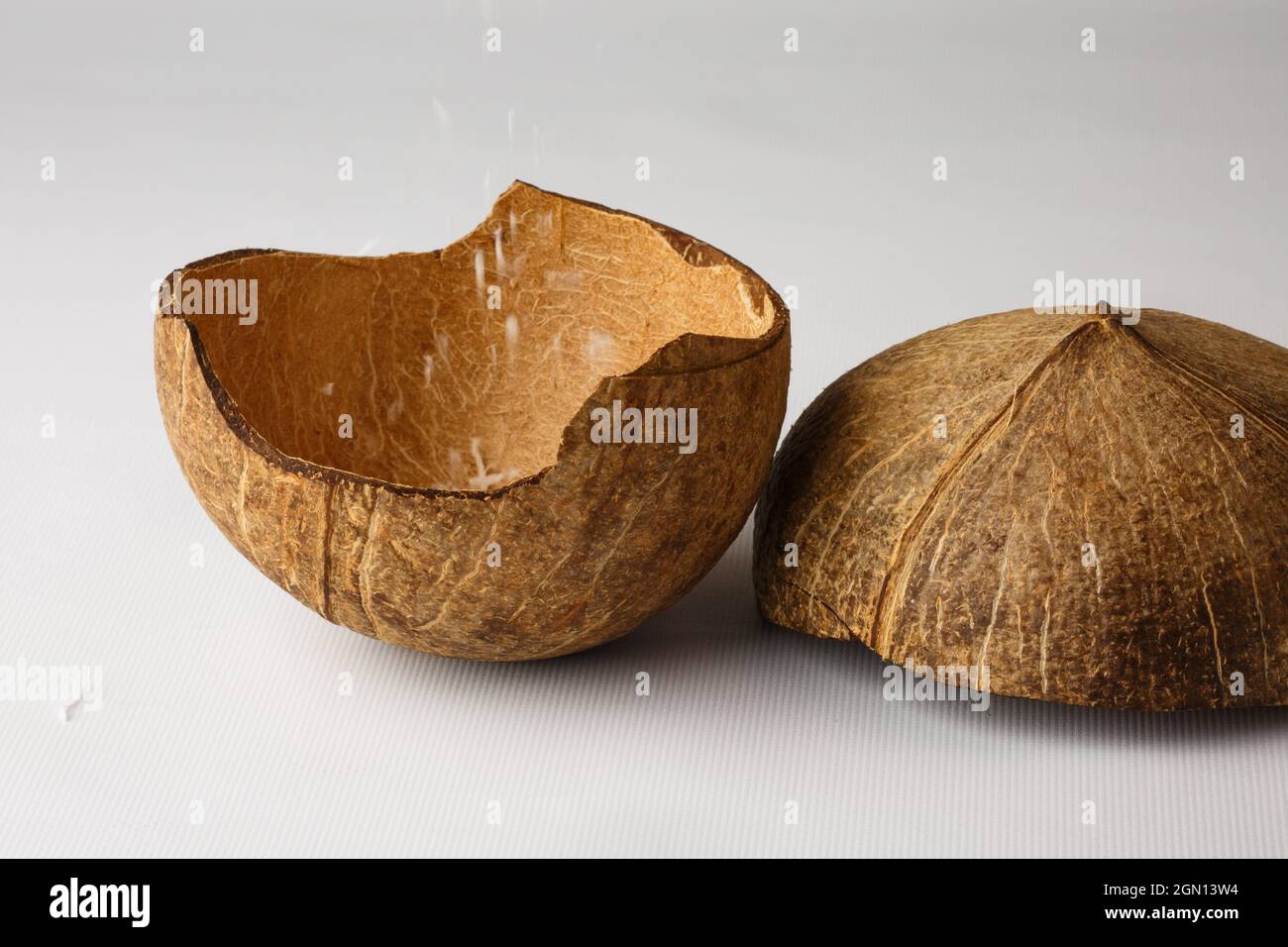 Coconut shell isolated on white background. The coconut flakes are removed from the inside of the coconut shell. Stock Photo