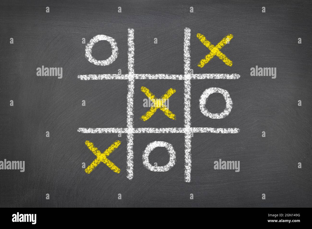A game of tic tac toe played on a chalk board shows the need to be a critical thinker in the world of gaming. Stock Photo