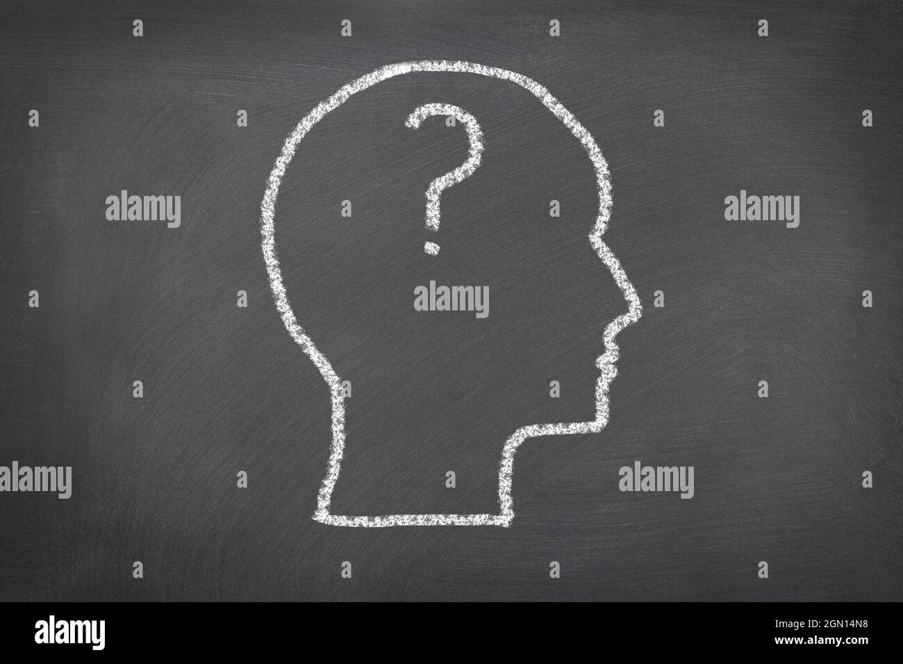 A chalk sketch on a blackboard of a human head and question mark that represents thoughts and ideas, problems, and confusion.  For use as any science Stock Photo