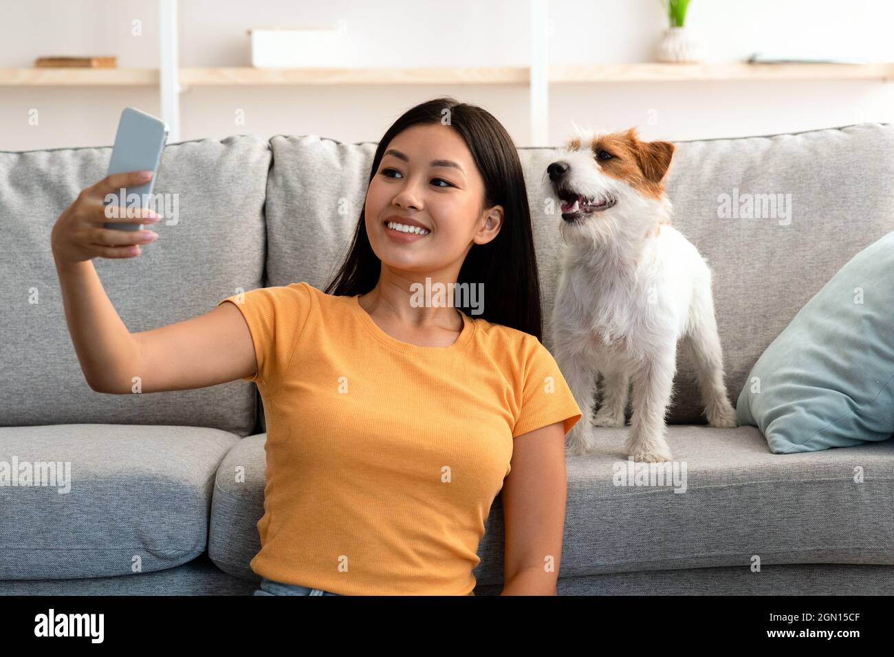 Smiling young asian woman taking selfie with her cute dog Stock Photo ...