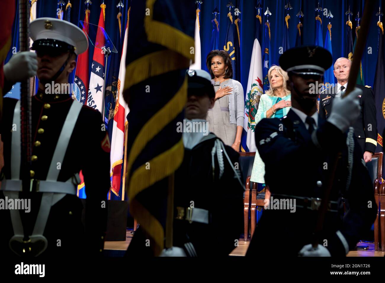 First Lady Michelle Obama, Dr. Jill Biden, and Gen. Martin Dempsey, Chairman of the Joint Chiefs of Staff, stand for the national anthem at the Pentagon in Arlington, Va., Feb. 15, 2012. During the event a report was unveiled outlining opportunities and best practices for states to better support military spouses serving in professions with state licensure requirements. (Official White House Photo by Chuck Kennedy) This official White House photograph is being made available only for publication by news organizations and/or for personal use printing by the subject(s) of the photograph. The pho Stock Photo