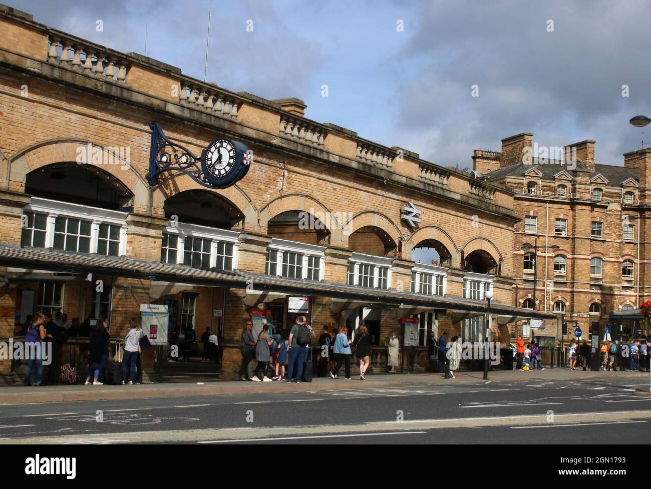 Exterior of the main entrance to York railway station with people, bus stop, station clock and British Rail double arrow logo, 11th September 2021. Stock Photo