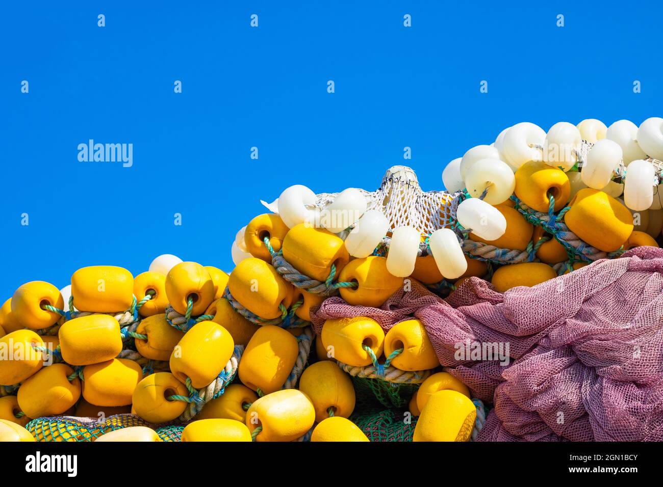 Heap of yellow fishing net floats on the blue sky background. fishing