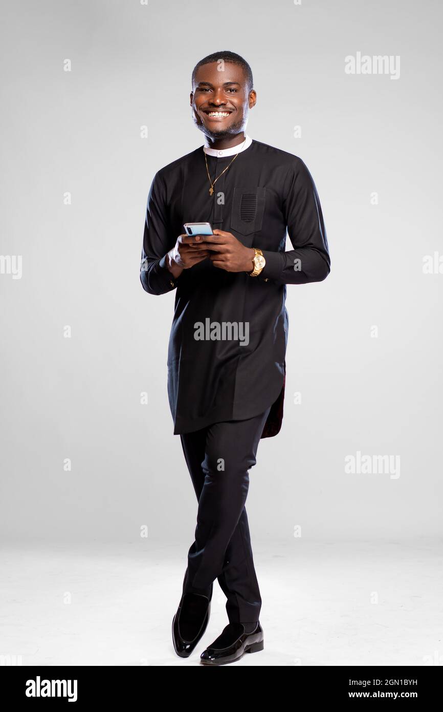 handsome young african man smiling while using his phone Stock Photo