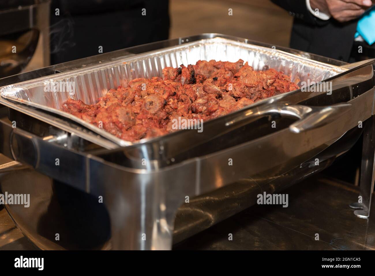 Chafing dish full of roasted lamb meat ready to serve party guest at