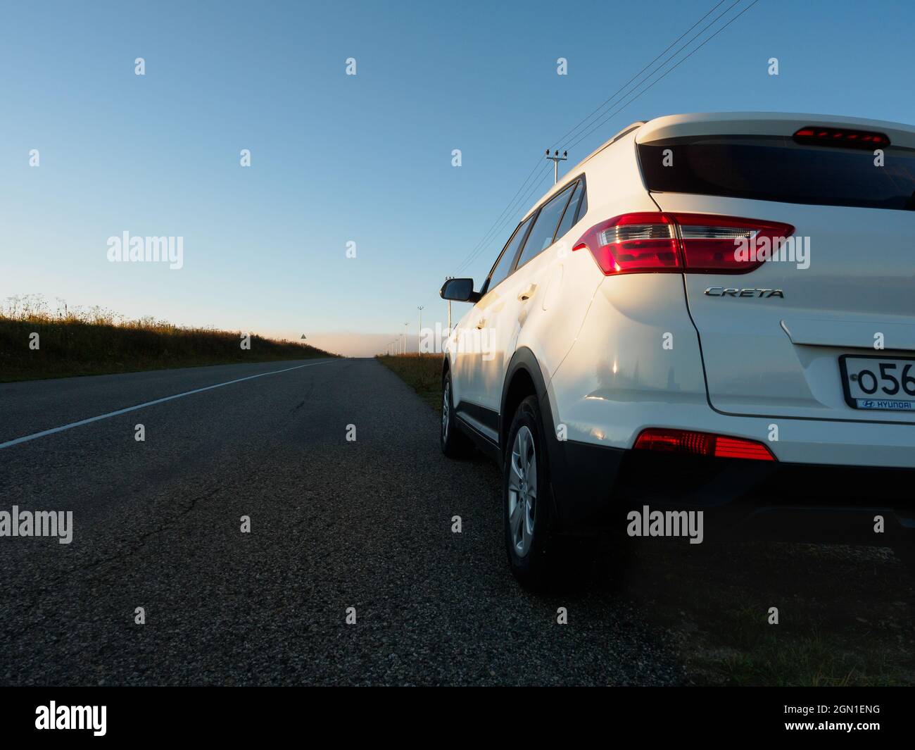 North Caucasus, Russia - 09 08 2021: SUV car on the road throught the fields at sunrise. Hyundai Creta Stock Photo