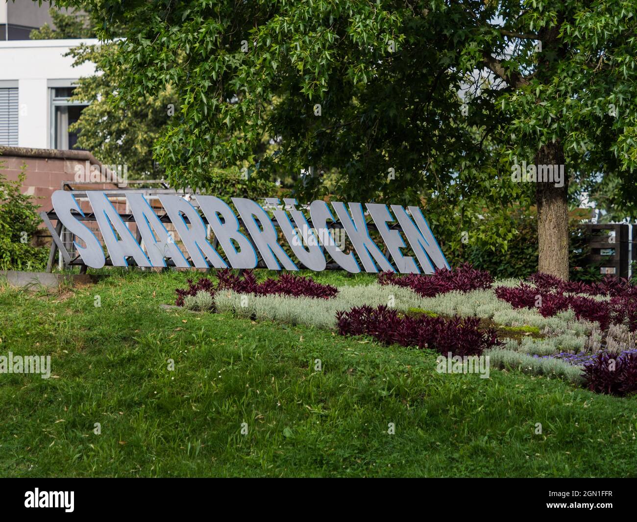 Flower garden and a Saarbrucken city sign in daylight in Germany Stock