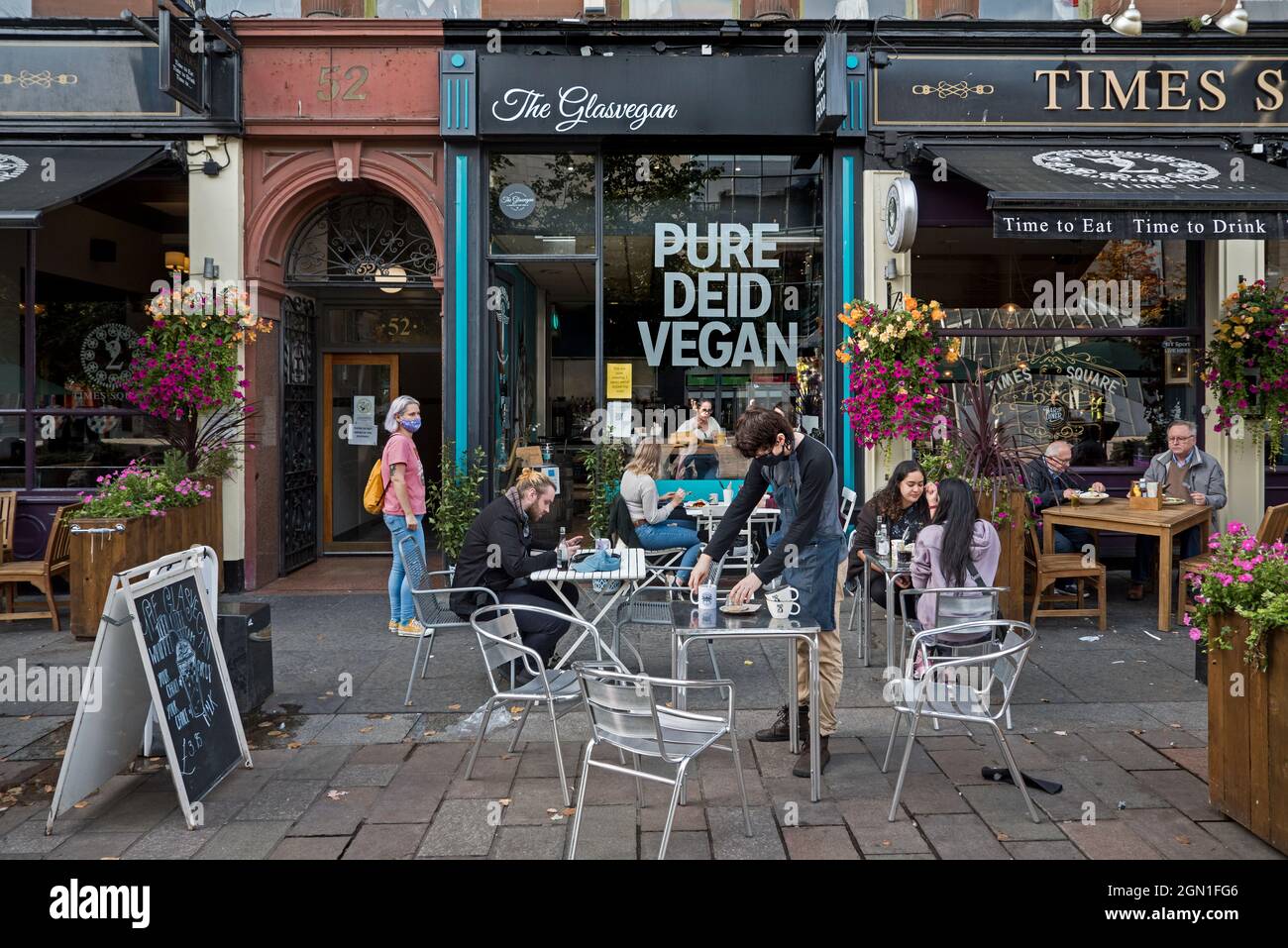 Customers sitting outside The Glasvegan, a vegan restaurant cafe in St Enoch Square, Glasgow,Scotland, UK. Stock Photo