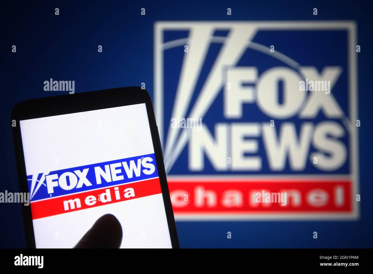 In this photo illustration a Fox News Channel (FNC) logo is seen on a smartphone and a pc screen. Stock Photo