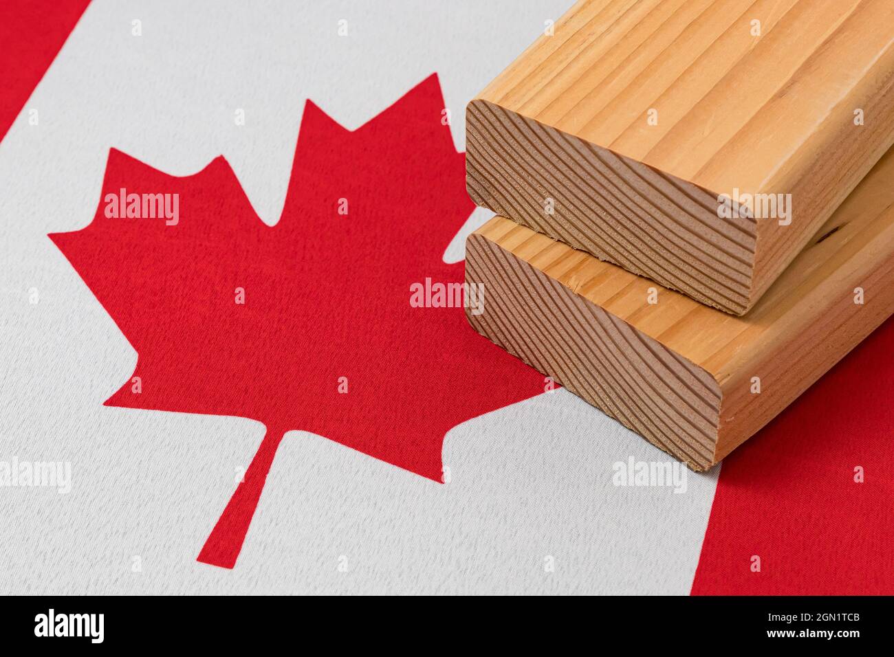 Softwood construction lumber on flag of Canada. Trade war, tariffs, fair trade and lumber, logging industry concept. Stock Photo