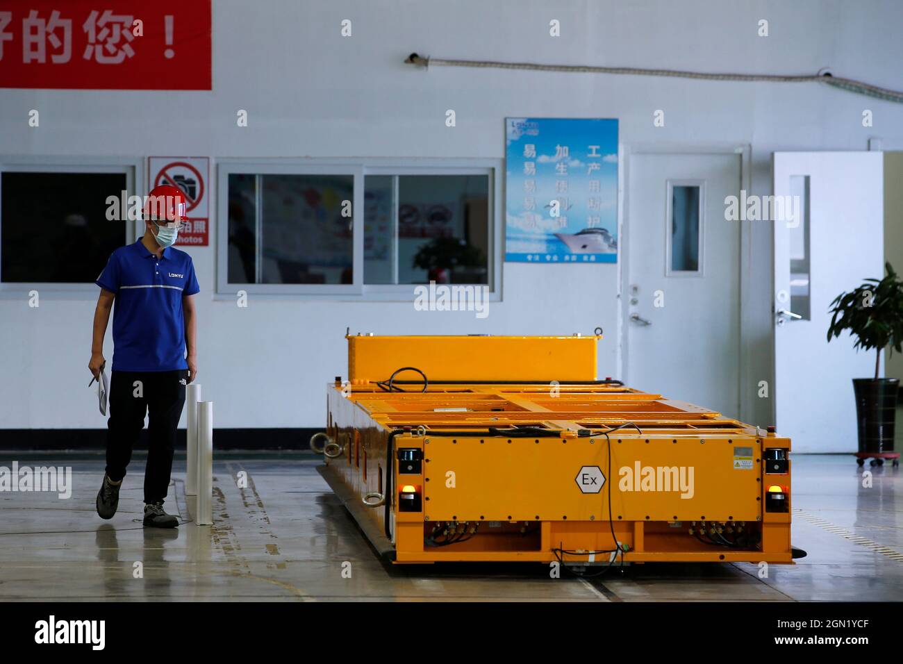 An employee inspects an automated guided vehicle (AGV) at a Lonyu Robot Co  factory in Tianjin, China, September 7, 2021. Picture taken September 7,  2021. REUTERS/Tingshu Wang Stock Photo - Alamy