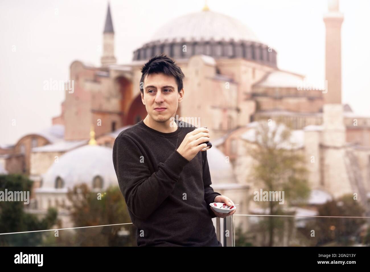 A young man drinks traditional Turkish tea. Stock Photo