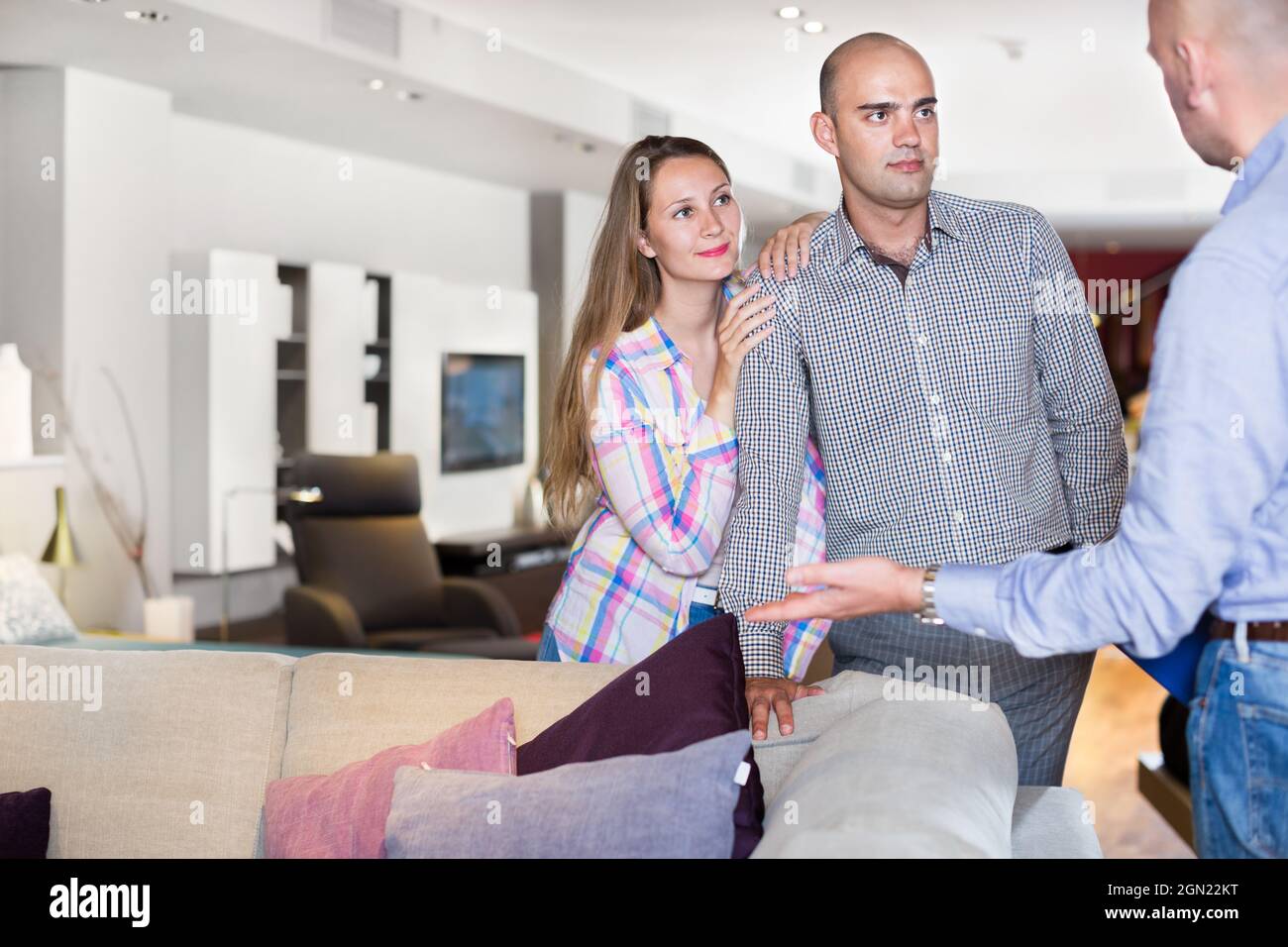 Salesman offering furniture to family couple Stock Photo Alamy
