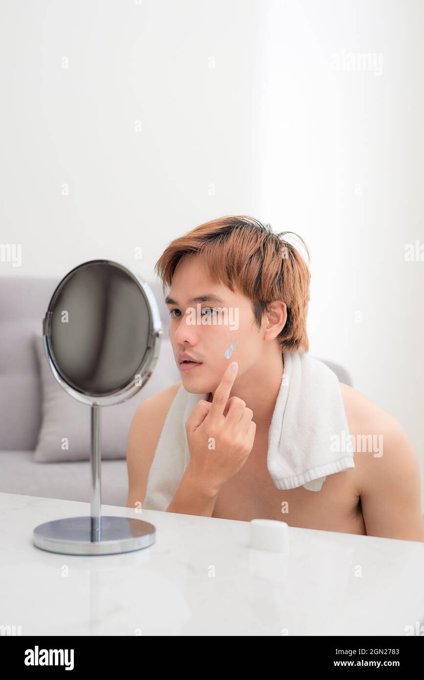 smiling man applying cream lotion on face Stock Photo Alamy
