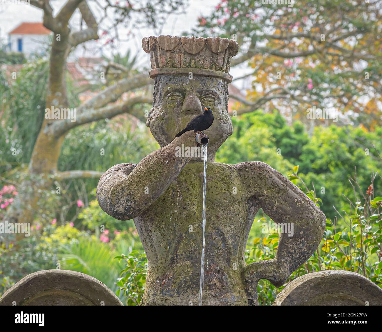 Stylized fountain sculpture of a man playing a flute with a black bird in the Duke of Terceira Garden (Jardim Duque da Terceira) in Angra do Heroismo Stock Photo