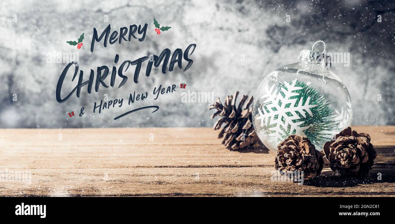 Merry Christmas and happy new year sign with Christmas tree  bauble and pine cone on wood table with concrete wall for celebrate holiday greeting card Stock Photo