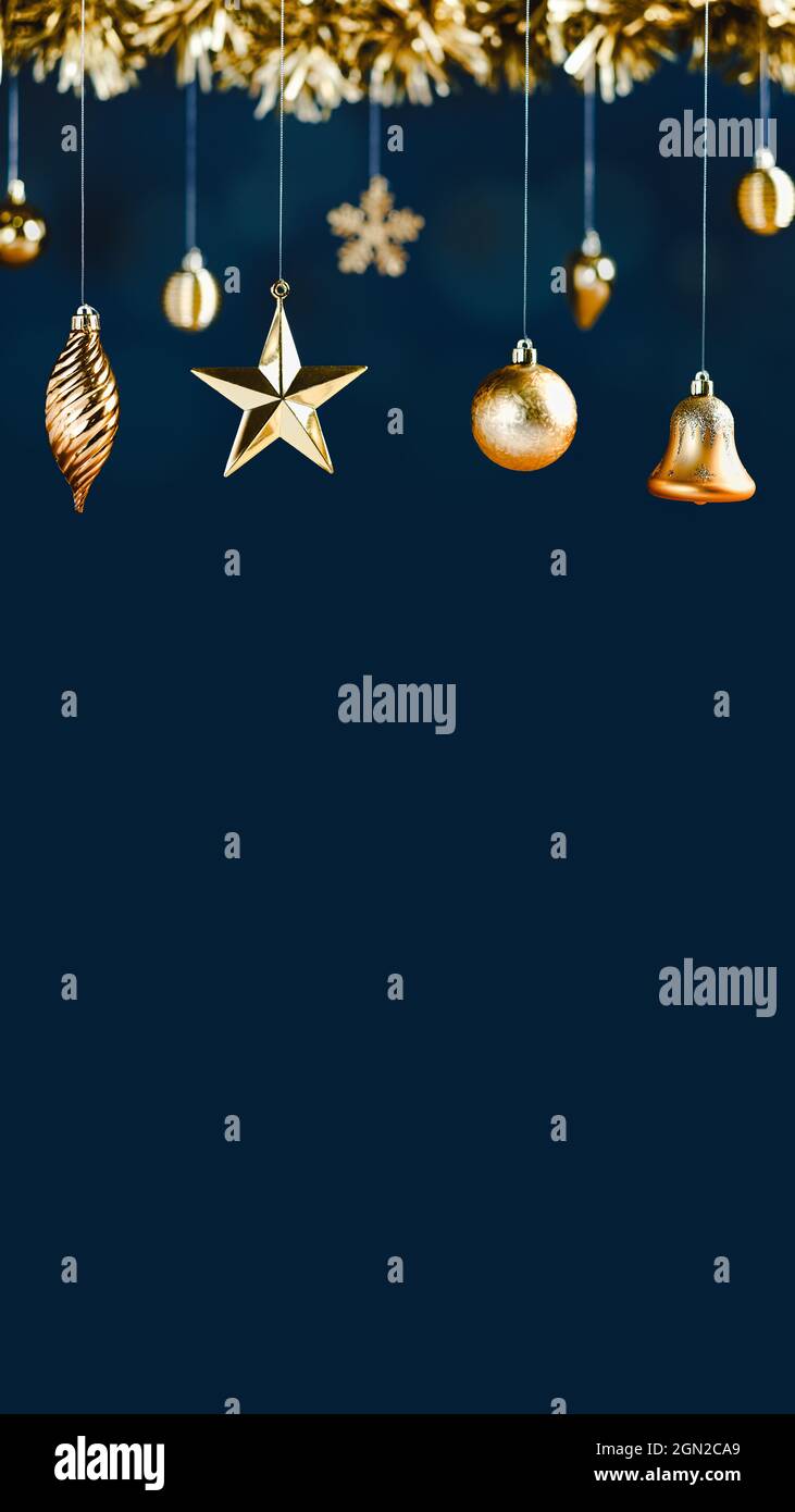 merry Christmas decoration golden star bell bauble and tinsel on navy luxury blue vertical background.banner mockup space for display of product or de Stock Photo