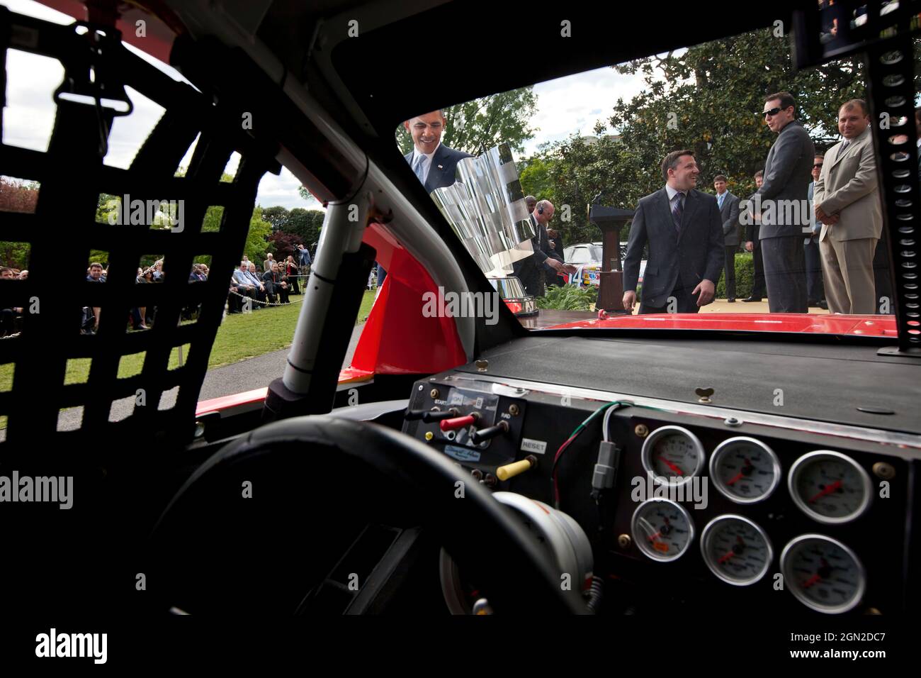 President Barack Obama looks at the NASCAR Sprint Cup Series Championship trophy as he approaches Tony Stewart's car during an event on the South Lawn of the White House, April 17, 2012. NASCAR Sprint Cup Series drivers Tony Stewart, center, Kyle Busch, and Ryan Newman, right, watch nearby. (Official White House Photo by Chuck Kennedy) This official White House photograph is being made available only for publication by news organizations and/or for personal use printing by the subject(s) of the photograph. The photograph may not be manipulated in any way and may not be used in commercial or po Stock Photo