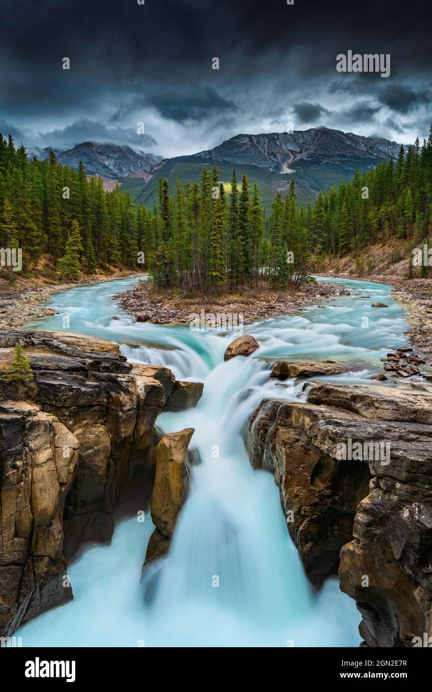 CANADA, ALBERTA, JASPER NATIONAL PARK. VIEW OF THE UPPER PLATEAU OF THE SUNWAPTA WATERFALL WITH ITS FOREST OF MELEZES. WATER COMES FROM THE ATHABASCA Stock Photo