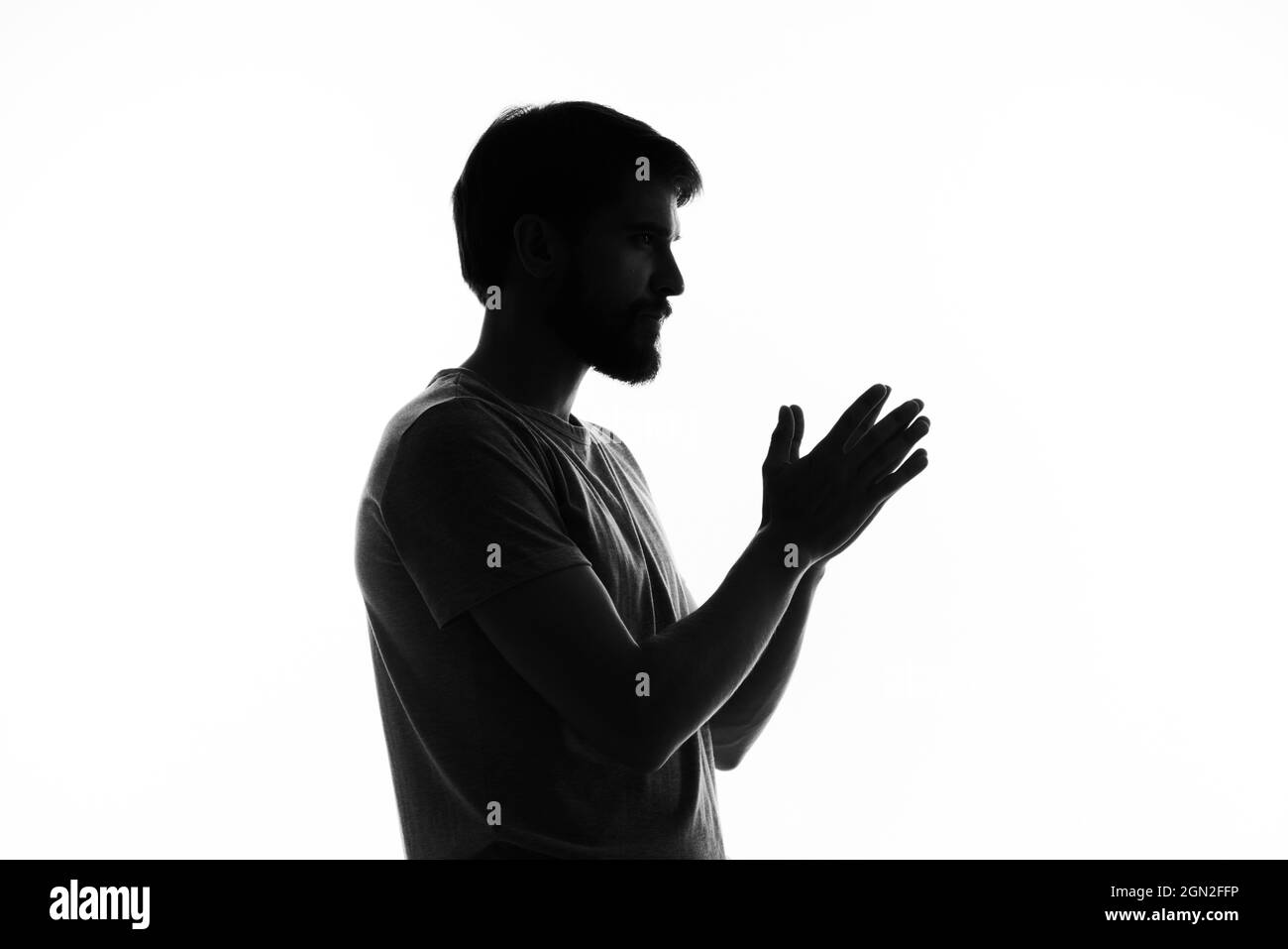 silhouette of a man in the shadows gesture with hands basing studio ...
