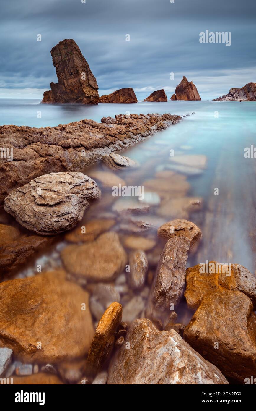 SPAIN, CANTABRIA, LIENCRES. VIEW FROM BELOW OF ARNIA BEACH WITH ITS CUT ROCKS Stock Photo