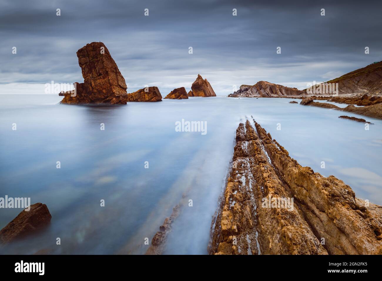 SPAIN, CANTABRIA, LIENCRES. VIEW FROM BELOW OF ARNIA BEACH WITH ITS CUT ROCKS Stock Photo