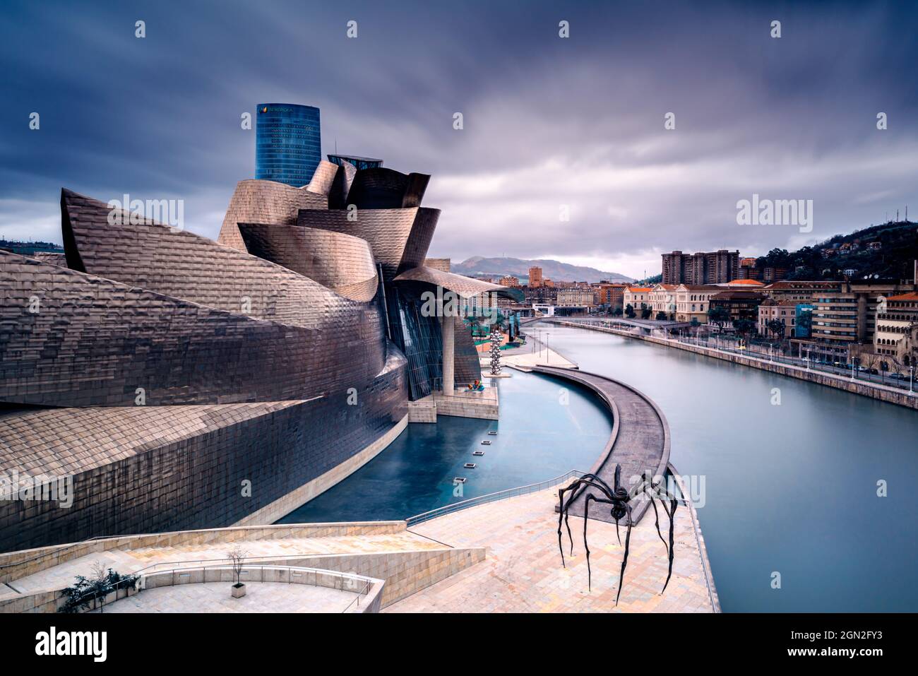 SPAIN, SPANISH BASQUE COUNTRY. BISCAY. BILBAO. NORTH FACADE OF THE GUGGENHEIM MUSEUM IN BILBAO (ARCHITECT FRANK GEHRY) WITH A VIEW OF THE SCULPTURE OF Stock Photo