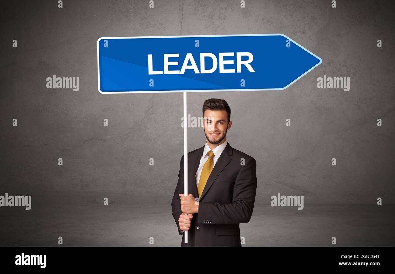 Young business person in casual holding road sign Stock Photo