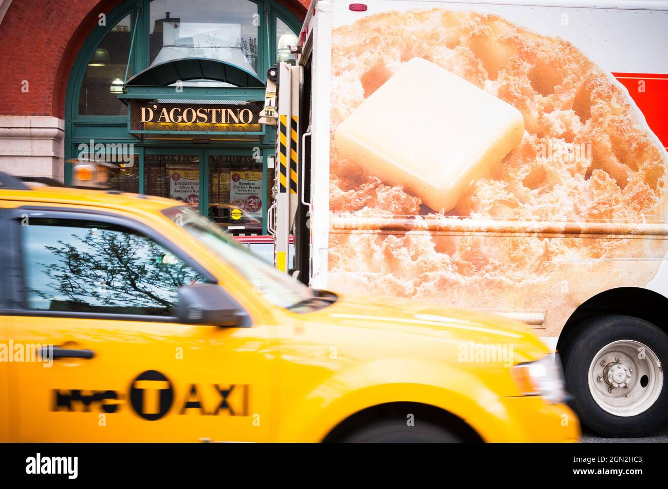 UNITED STATES, NEW YORK, MANHATTAN, COMMERCE AGOSTINO WITH A DELIVERY TRUCK AND A YELLOW CAB IN THE FOREGROUND Stock Photo