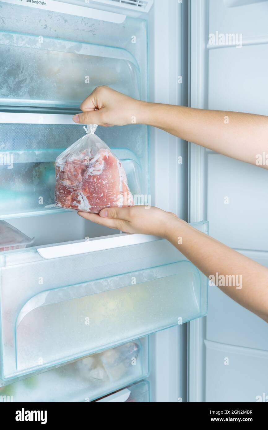 Taking frozen meat from the modern no-frost freezer Stock Photo