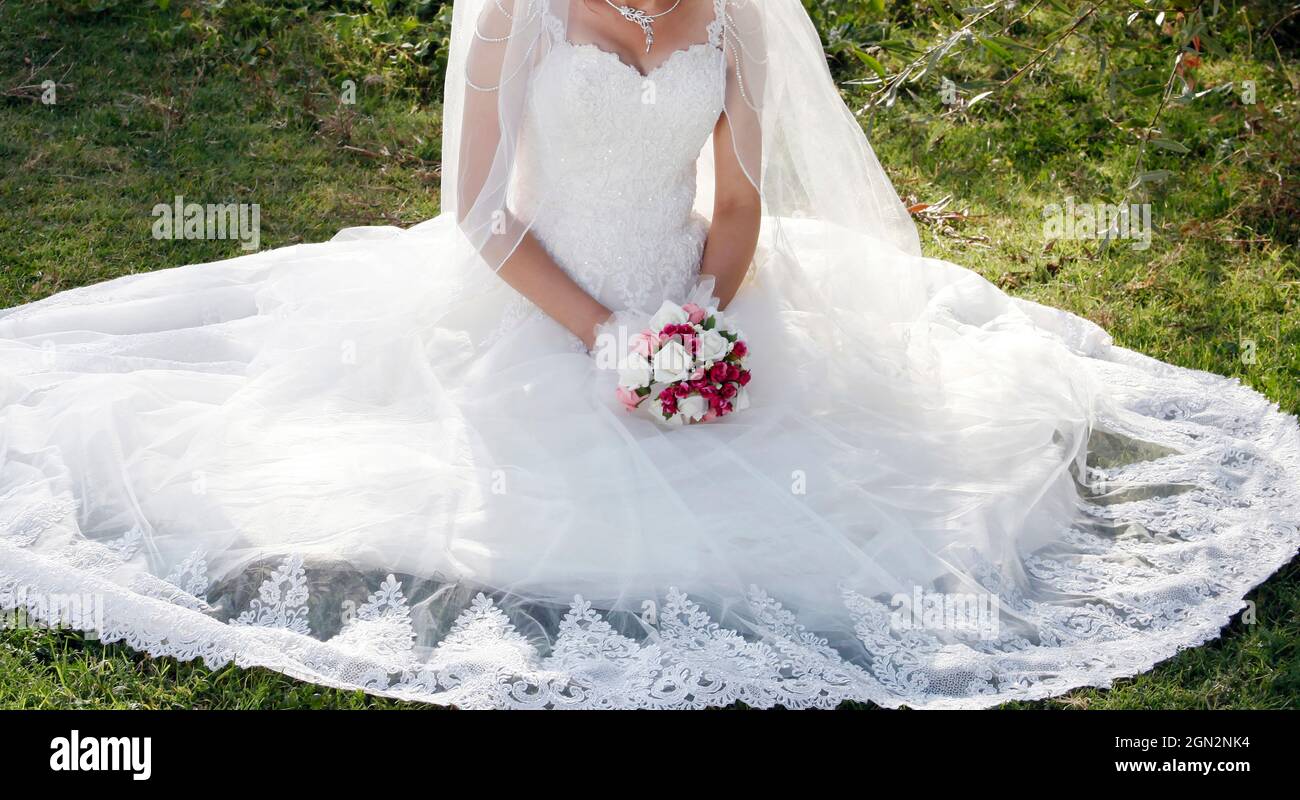 Bride in white wedding dress with lace, embroidery. A bouquet of ...