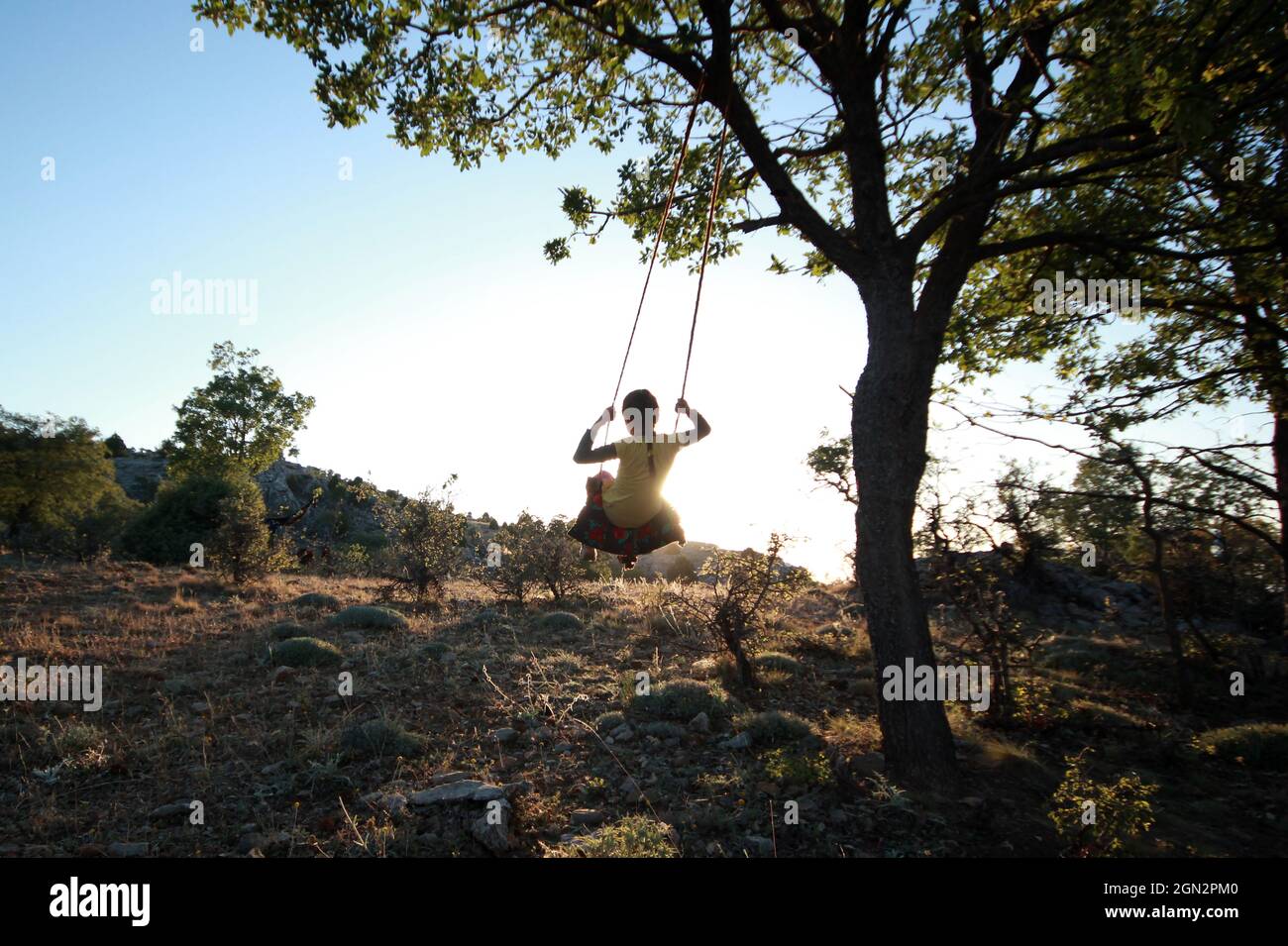 girl swinging freely in nature Stock Photo