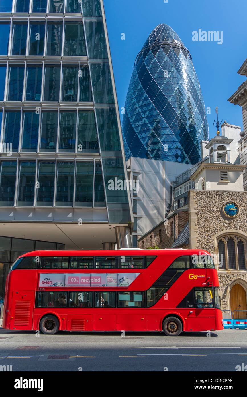 View of The Gherkin peaking between other contemporary architecture and red bus, City of London, London, England, United Kingdom, Europe Stock Photo