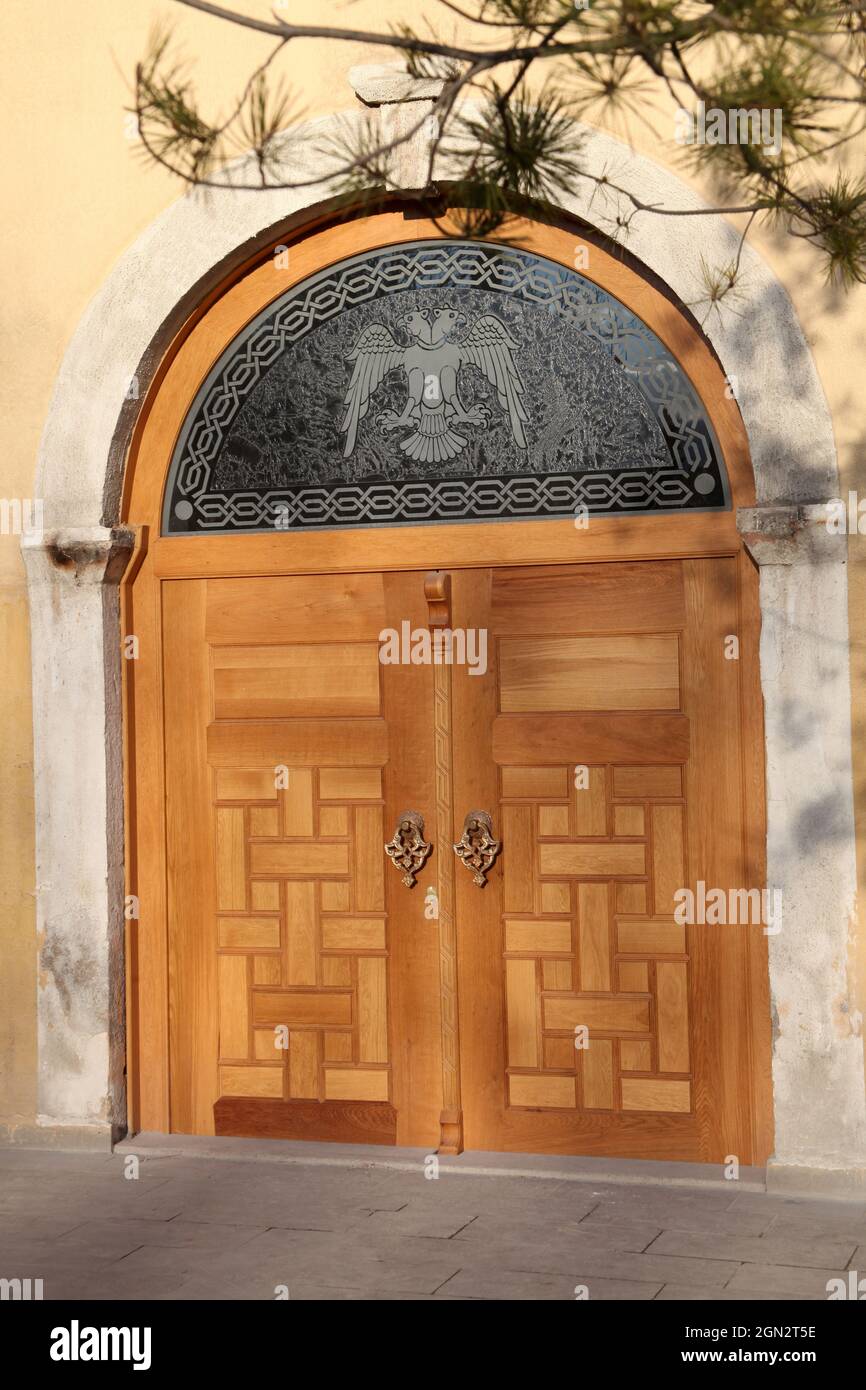 Historical building and wooden gate. Double headed eagle figure. Stock Photo