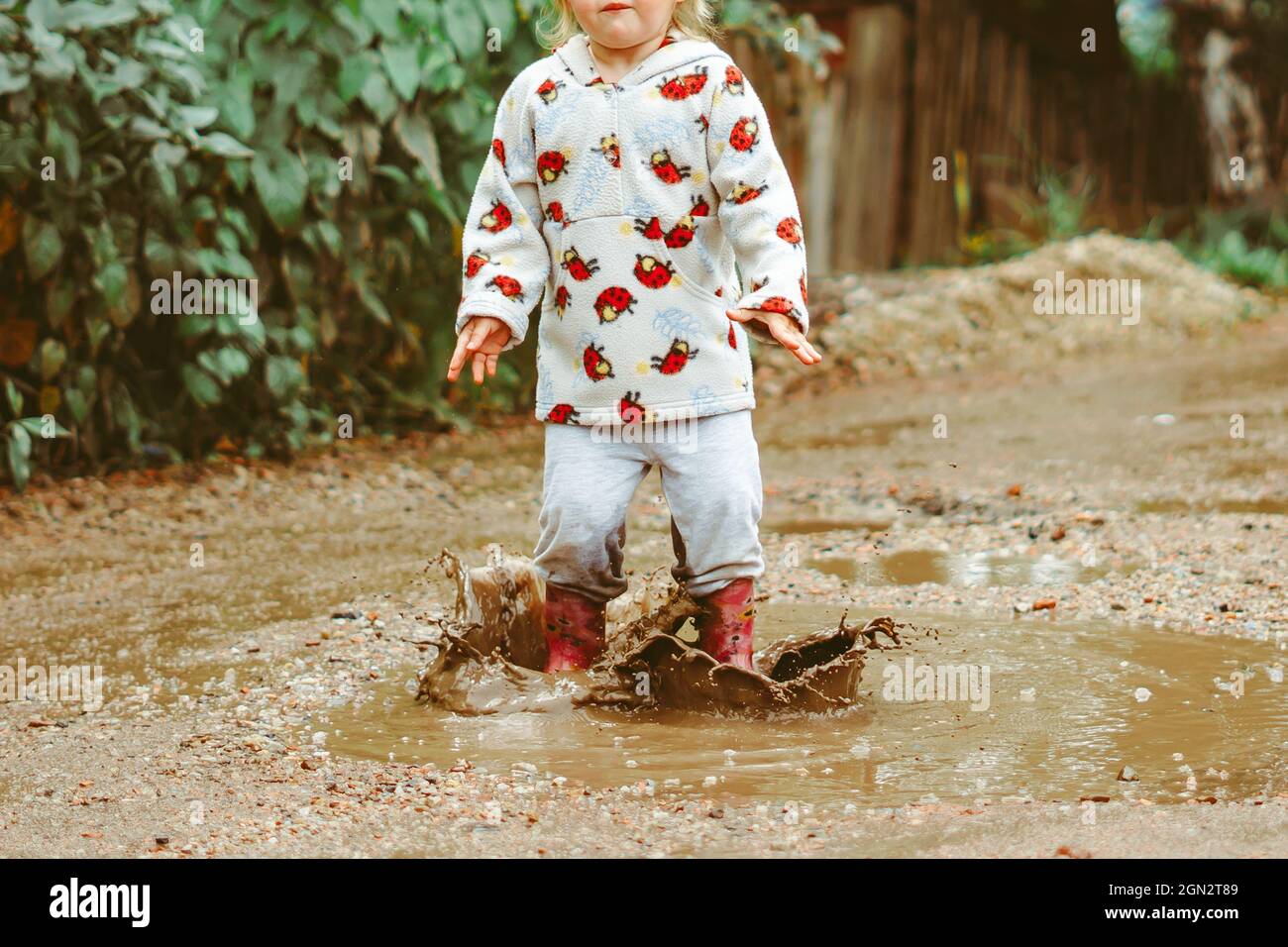 a child runs through puddles in rubber boots Stock Photo - Alamy