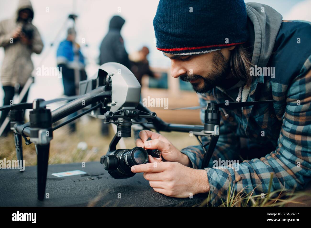 Man pilot checking quadcopter drone camera before aerial flight and filming Stock Photo